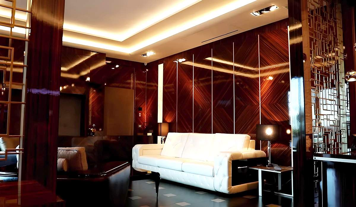 La Serenity Room arredata: pareti in legno, luci calde e divano bianco